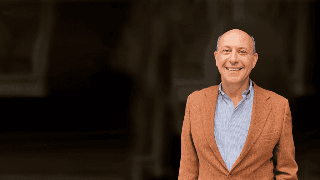 Dr. Edvin Turkof lächelnd im braunen Sakko, Porträtfoto