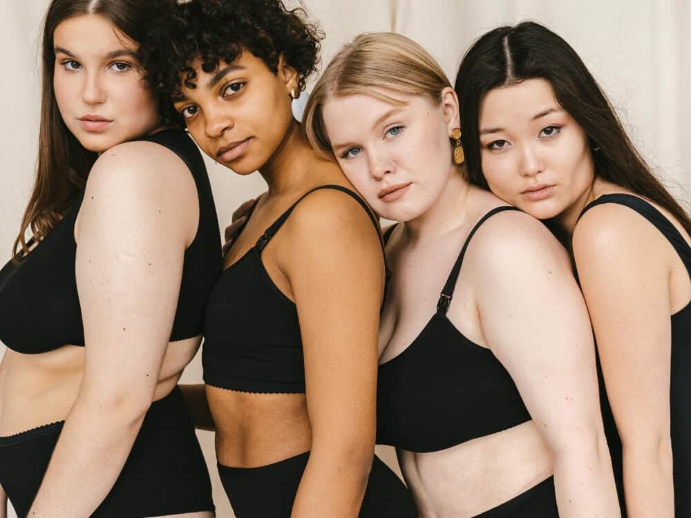 Vier Frauen in schwarzen Unterwäsche, Selbstbewusstsein und Vielfalt feiern.